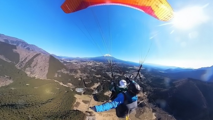 静岡・朝霧高原で行うパラグライダーのタンデム体験。インストラクター同乗で初心者でも安心して空中散歩を楽しんでいる様子